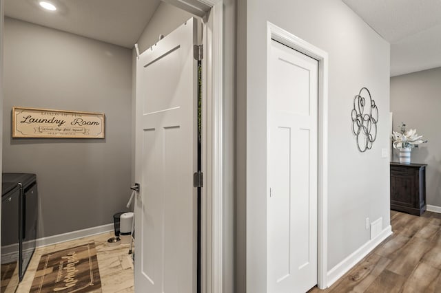 bathroom featuring hardwood / wood-style flooring and washing machine and clothes dryer