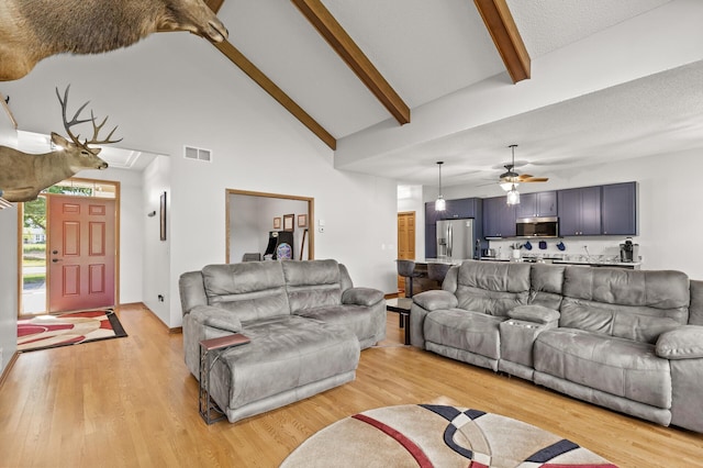 living room with beamed ceiling, light hardwood / wood-style flooring, and high vaulted ceiling