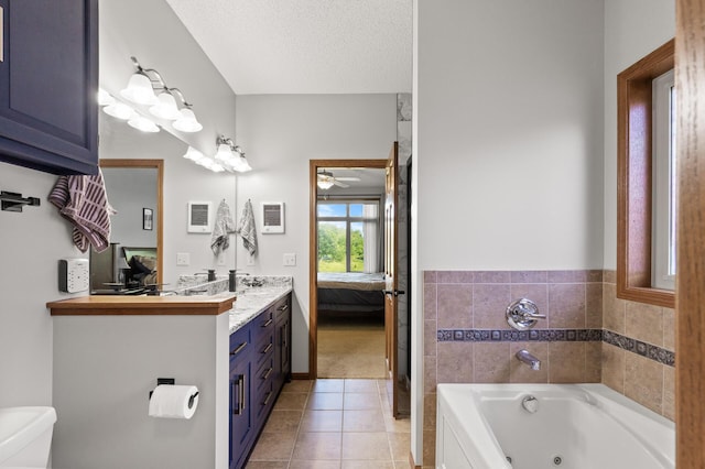 bathroom with tile patterned floors, a bath, toilet, a textured ceiling, and vanity