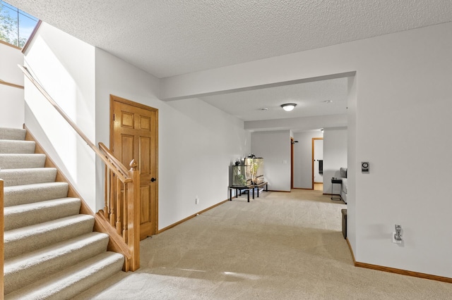 interior space featuring a textured ceiling and light carpet