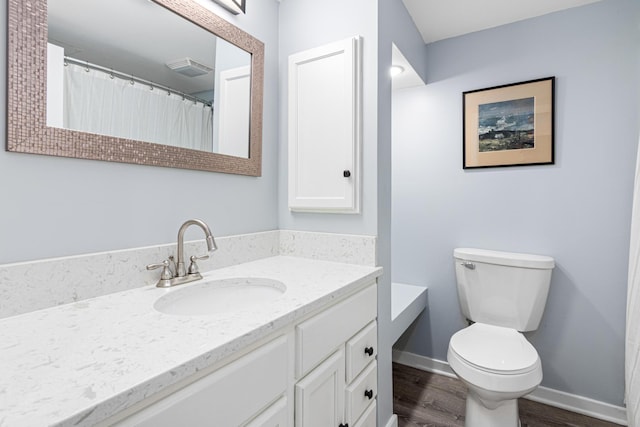 full bathroom with wood finished floors, toilet, vanity, and baseboards