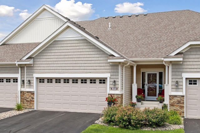 8160 Virginia Ln, Savage, MN 55378 - view of front facade featuring stone siding, asphalt driveway, a shingled roof, and an attached garage