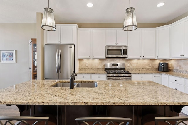 8160 Virginia Ln, Savage, MN 55378 - kitchen with stainless steel appliances, a breakfast bar area, white cabinetry, decorative backsplash, and recessed lighting