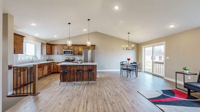 kitchen with pendant lighting, a kitchen island, stainless steel appliances, tasteful backsplash, and a kitchen breakfast bar