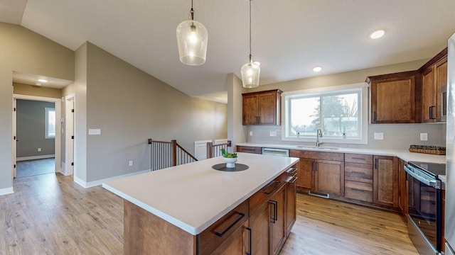 kitchen featuring a kitchen island, sink, backsplash, hanging light fixtures, and stainless steel electric range