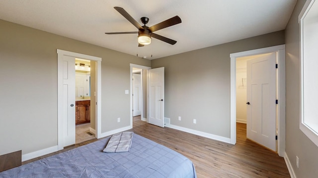 unfurnished bedroom with ceiling fan, light hardwood / wood-style floors, and ensuite bath