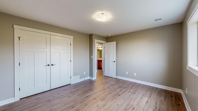 unfurnished bedroom with a closet and light wood-type flooring