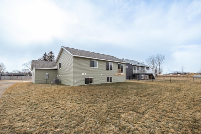 rear view of house with a lawn and cooling unit