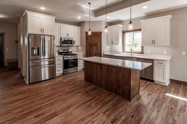 kitchen featuring white cabinets, stainless steel appliances, a center island, and pendant lighting