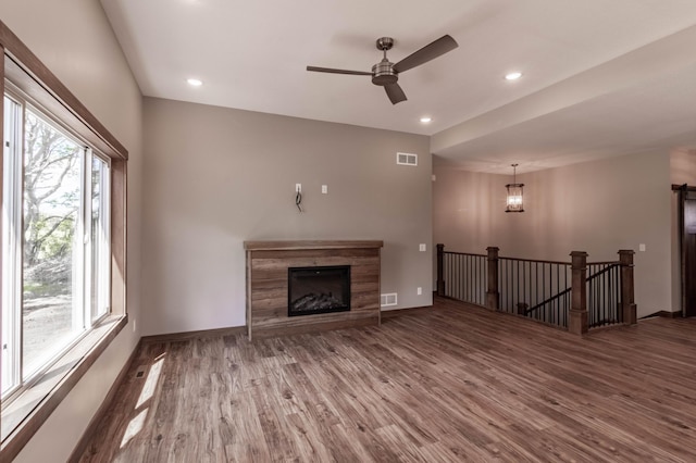 unfurnished living room featuring ceiling fan and hardwood / wood-style floors