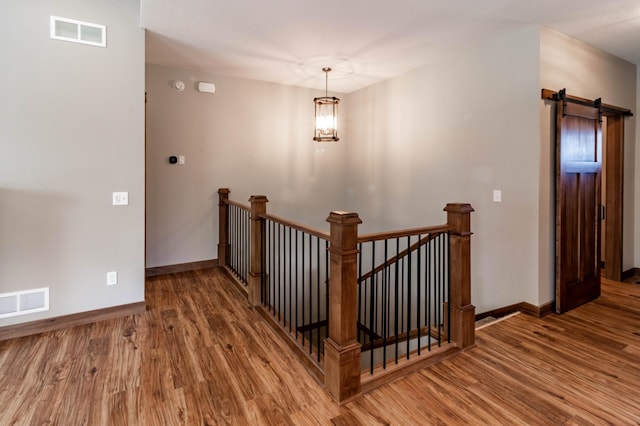 staircase featuring hardwood / wood-style flooring and a barn door