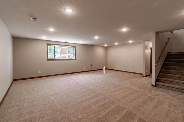 basement featuring a textured ceiling and light carpet