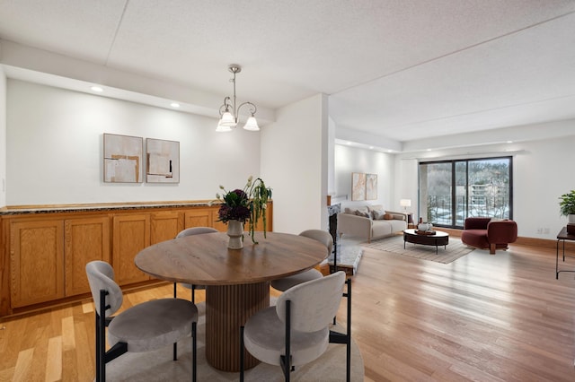 dining area with an inviting chandelier and light hardwood / wood-style flooring