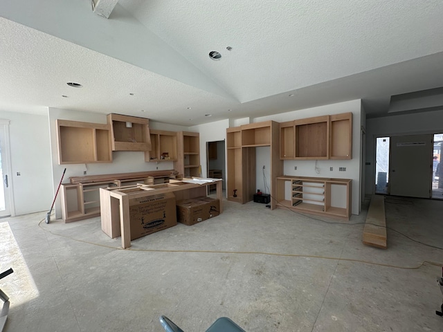 kitchen featuring a textured ceiling and lofted ceiling