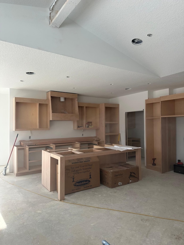 kitchen with a textured ceiling and vaulted ceiling