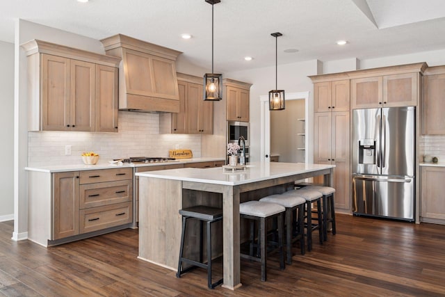 kitchen with a breakfast bar area, dark wood-type flooring, a sink, appliances with stainless steel finishes, and custom exhaust hood