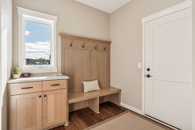 mudroom featuring dark wood-type flooring and baseboards