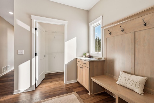 mudroom with dark wood-type flooring, visible vents, and baseboards