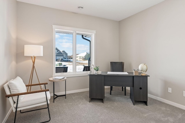 office area featuring light carpet and baseboards