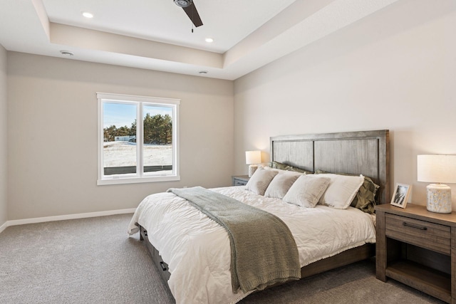 bedroom featuring carpet floors, a ceiling fan, baseboards, and a tray ceiling