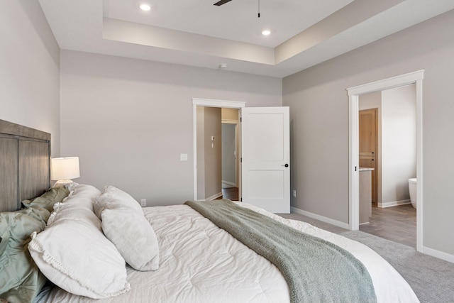 bedroom featuring light carpet, baseboards, a raised ceiling, and recessed lighting