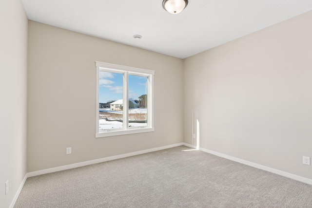 spare room with carpet and baseboards