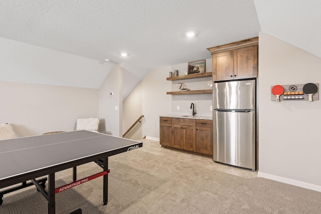 game room with light carpet, a sink, a textured ceiling, and baseboards