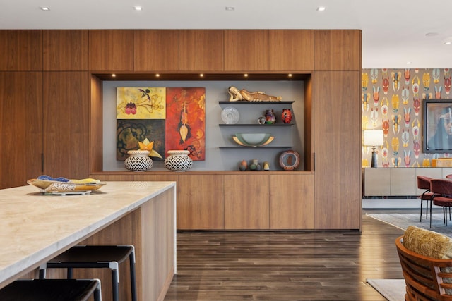 bar featuring light stone countertops and dark hardwood / wood-style flooring