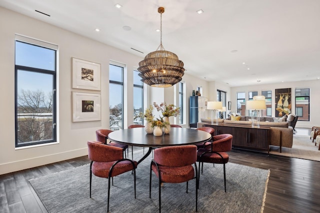 dining room with an inviting chandelier, plenty of natural light, and dark hardwood / wood-style floors