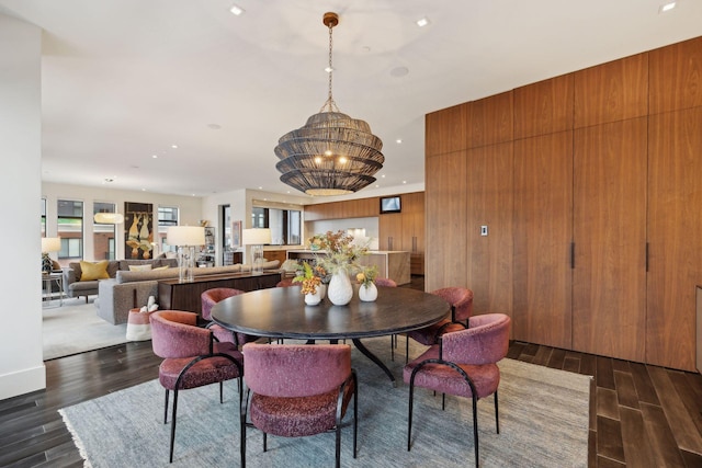 dining area featuring dark wood-type flooring and a notable chandelier