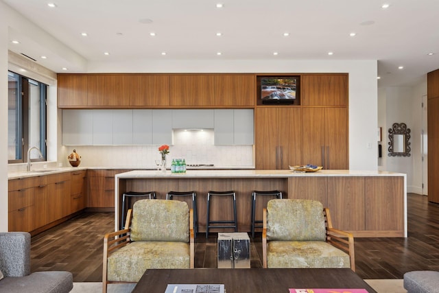 kitchen with sink, backsplash, white cabinets, and dark hardwood / wood-style flooring