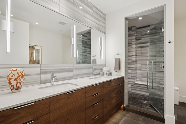 bathroom with vanity, tasteful backsplash, tile patterned floors, and walk in shower