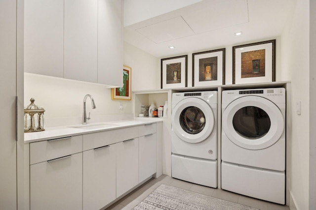 laundry room featuring cabinets, washing machine and clothes dryer, sink, and light tile patterned floors