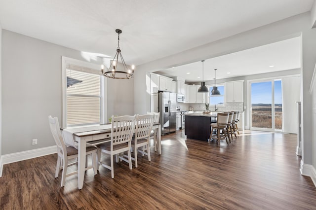 dining space with baseboards, dark wood-style flooring, and a notable chandelier