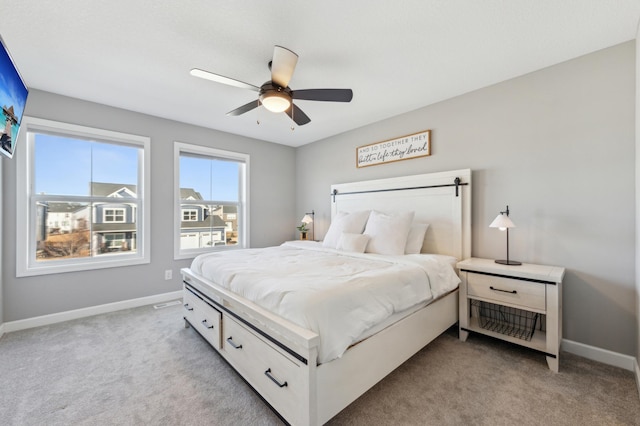 bedroom featuring light carpet, baseboards, and a ceiling fan