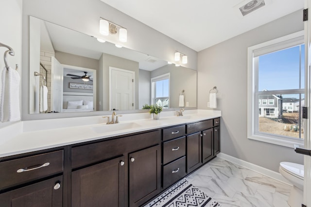 full bath with marble finish floor, double vanity, visible vents, a sink, and baseboards