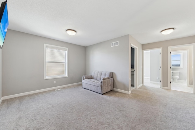 unfurnished room with carpet, visible vents, plenty of natural light, and baseboards