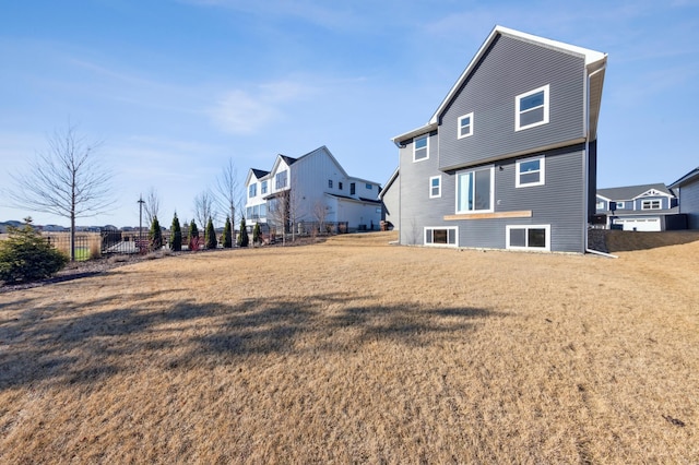 rear view of property with a yard and fence