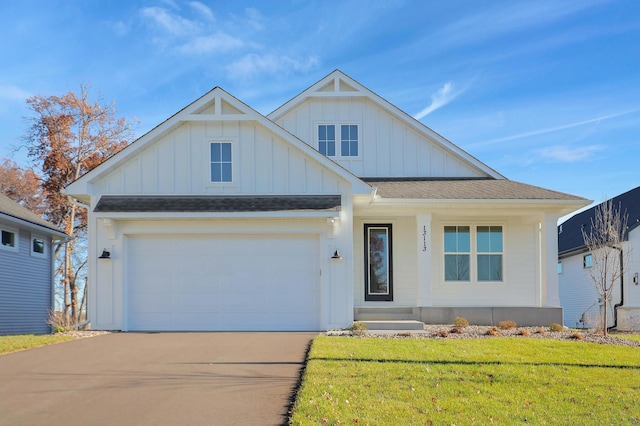 13104 Ghia Ct NE, Blaine, MN 55449 - view of front of house with board and batten siding, concrete driveway, a front lawn, and a garage
