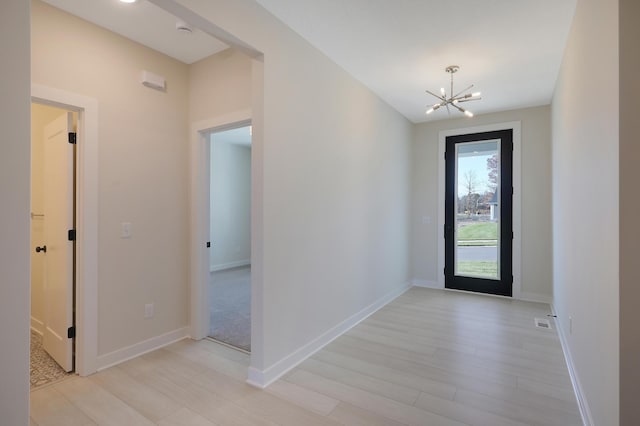 13104 Ghia Ct NE, Blaine, MN 55449 - entrance foyer with a chandelier, light wood-style flooring, and baseboards