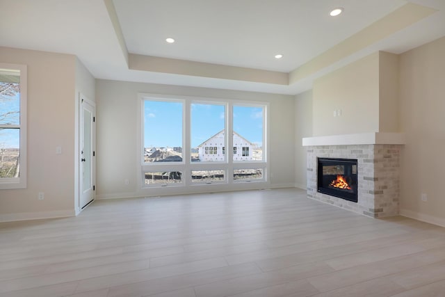 13104 Ghia Ct NE, Blaine, MN 55449 - unfurnished living room featuring plenty of natural light, a glass covered fireplace, light wood finished floors, and recessed lighting