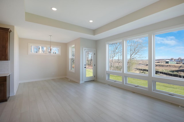 13104 Ghia Ct NE, Blaine, MN 55449 - unfurnished dining area featuring a chandelier, healthy amount of natural light, light wood-style floors, a tray ceiling, and recessed lighting