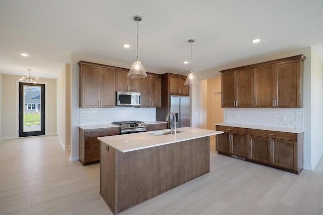 13104 Ghia Ct NE, Blaine, MN 55449 - kitchen featuring stainless steel appliances, a sink, tasteful backsplash, light wood-style floors, and recessed lighting