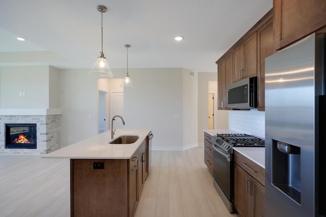 13104 Ghia Ct NE, Blaine, MN 55449 - kitchen featuring stainless steel appliances, a sink, backsplash, light wood-type flooring, and light countertops