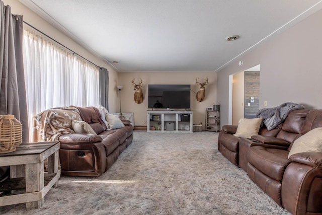 carpeted living area featuring visible vents and crown molding