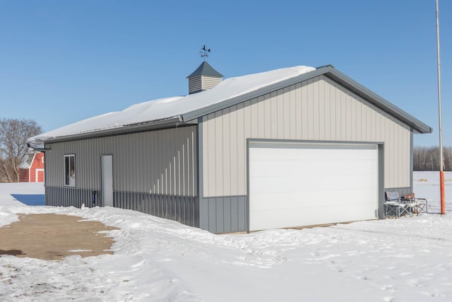 snow covered garage with a garage