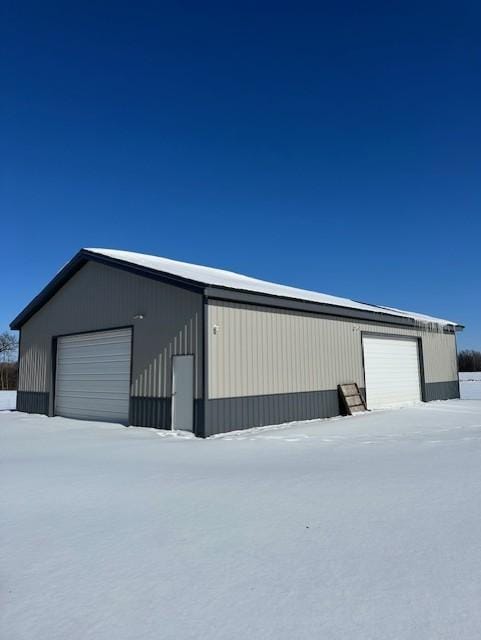 snow covered garage with a garage