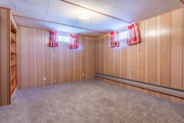 below grade area featuring wood walls, carpet flooring, and baseboard heating