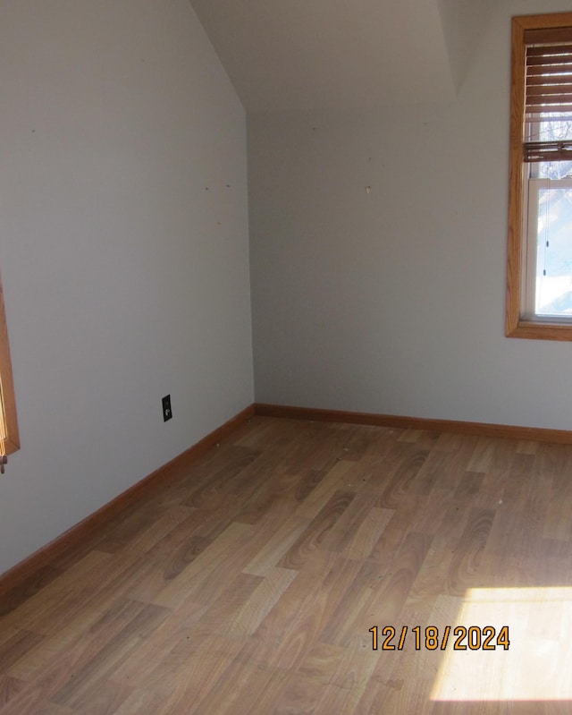 empty room with lofted ceiling and hardwood / wood-style floors