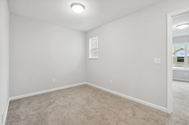 spare room featuring carpet flooring and baseboards